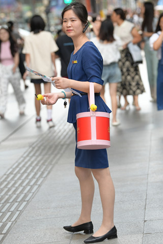 街拍发小礼品的金店促销员