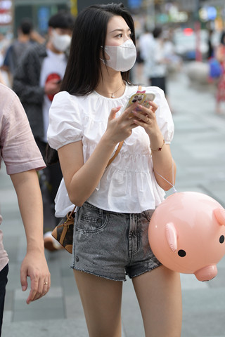 街拍拿着可爱气球的热裤小姐姐