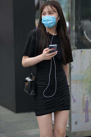 街拍听歌的黑色包臀裙小妞